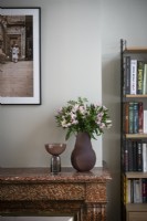 Vase of flowers on brown marble mantelpiece 