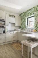 Tropical patterned wall paper on feature wall of modern kitchen 