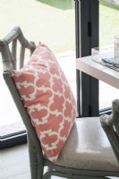 Pink cushion on grey wicker dining chair - detail 