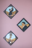 Display of paintings on pink painted wall - detail 