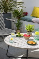 Food and drink on garden table in small courtyard 