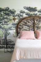 Mural feature wall behind bed with decorative wicker headboard 