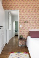 Modern bedroom with colourful patterned wallpaper 