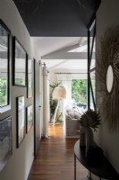 View along modern corridor to unusual floor lamp in living room 
