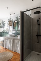 Modern shower cubicle in bathroom with tropical mural on wall
