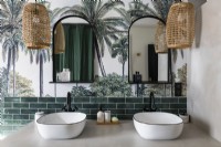 Modern twin sinks in bathroom with tropical scene mural on wall