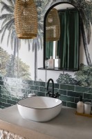 Sink in modern bathroom with tropical mural on wall