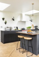 Modern country kitchen with dark cupboards, units, brass taps, island, pendants and wooden floors