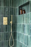Contemporary modern shower with vertical green tiles and gold, brass taps