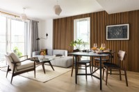 Open plan contemporary modern Japandi style living room with dining table and a slatted wall