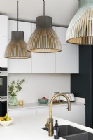 Contemporary white kitchen with, gold brass taps and light pendants
