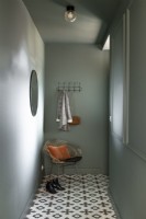 Narrow hallway with metal chair and coat hooks 