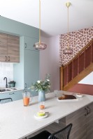 Modern pastel kitchen with colourful staircase on back wall