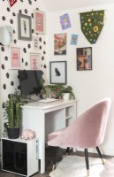 Modern desk and chair with colourful display of artwork on wall