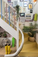 Colourful eclectic staircase with display of pictures on wall