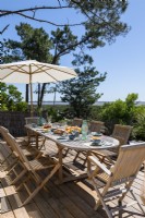 Outdoor dining area with coastal view in summer 