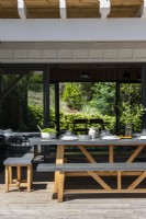 Outdoor dining area on decking with view through house 