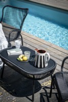 Black furniture next to swimming pool - detail