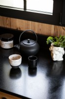 Tea pot and accessories on modern black kitchen worktop