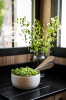 Salad bowl on black kitchen worktop - detail