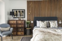 Modern bedroom with wooden slatted feature wall behind bed
