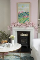 Pink floral garland on mantelpiece over wood burning stove