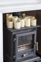 Collection of candles on top of small wood burning stove - detail