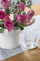 Pink roses in white vase on table - detail