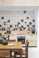 Modern kitchen-diner with geometric shapes on splashback tiling