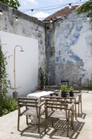 Wooden table and chairs in small courtyard garden