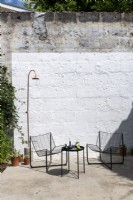 Black modern metal furniture in small courtyard garden