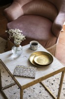 Dusky pink upholstered chair and gold coffee table