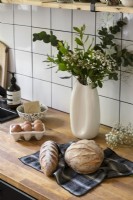 Flower arrangement and fresh bread on kitchen worktop