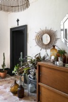 Houseplants and ornaments around sideboard in classic hallway