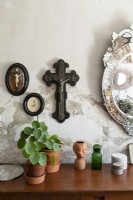 Religious ornaments and houseplants above sideboard - detail