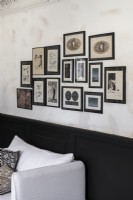Display of framed pictures on wall above dado rail