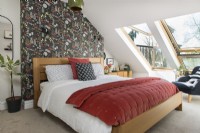 Modern bedroom with colourfully patterned wallpaper feature wall