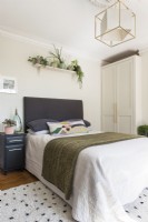 Modern bedroom wtih display of houseplants above bed