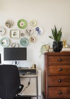 Display of wall mounted decorative plates on study wall
