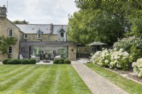 Formal country garden and terrace outside extended country house