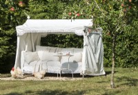 Large daybed with canopy in country garden