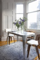 Small metal dining table in bay window
