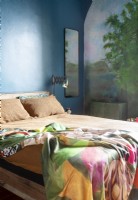 Colourful modern bedroom with mural painted on walls