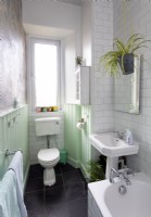 White bathroom with mint green painted woodwork