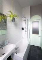 Modern white bathroom with mint green painted woodwork - door