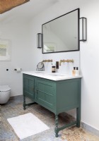 Green sink unit in modern bathroom