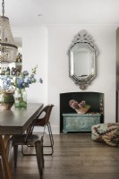 Mirror over disused fireplace in modern dining room