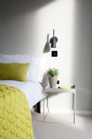 Bedside table and wall lamp in contemporary bedroom