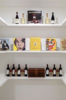 White shelves with display of wine and books