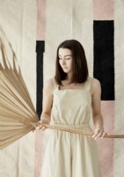 Woman holding large dried palm leaf 